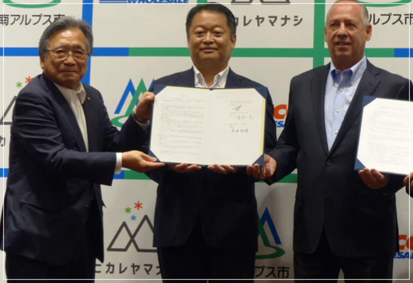 サインした協定書を持って写真撮影する県知事、市長、コストコ日本支社長