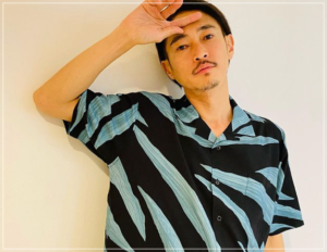 柄シャツを着てポージングする窪塚洋介