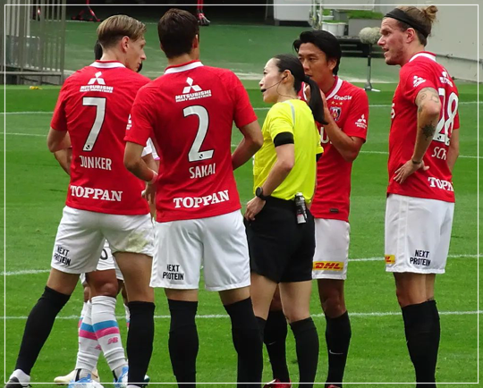 たくさんのプロサッカー選手に囲まれながらも毅然と対応する山下良美